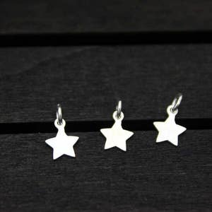 May include: Three silver star-shaped charms with a loop at the top.