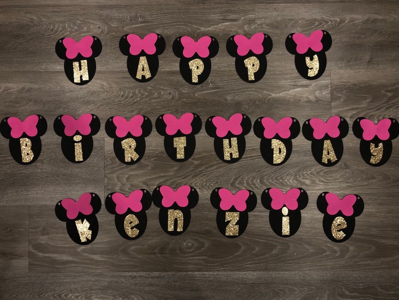 May include: Black and pink felt banner with gold glitter letters spelling "Happy Birthday Kenzie".