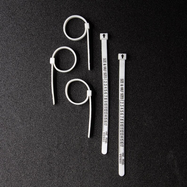 Pode incluir: Tr&ecirc;s calibradores de anel de pl&aacute;stico branco e duas fitas m&eacute;tricas de tamanho de anel de pl&aacute;stico branco. As fitas s&atilde;o marcadas com "SIZE & HALF SIZES" e n&uacute;meros de 1 a 17. As fitas s&atilde;o marcadas com "PAT, PEND. 9101693".
