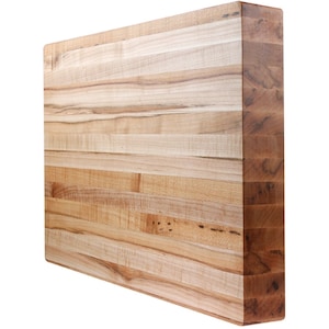 May include: A large, rectangular, wooden cutting board made of maple wood. The board has a natural wood finish and is made of multiple layers of wood.