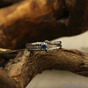May include: A silver engagement ring with a blue gemstone and small diamonds set in a branch-like design.