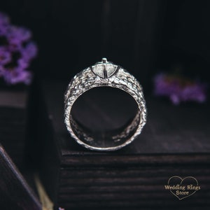 May include: A silver wedding band with a textured finish and a small diamond set in the center.