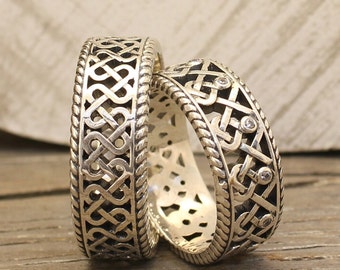 May include: Two silver rings with intricate Celtic knot designs. One ring has small clear stones set into the design.