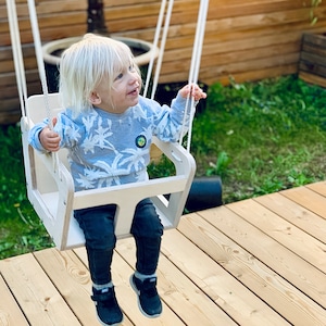 Natural wood-colored children&#39;s swing made of wood for outdoor use and the garden. Toddler swing, wooden swing, garden swing, baby swing
