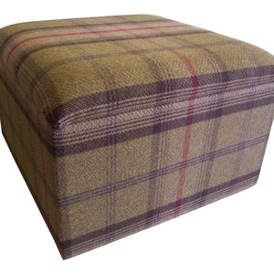 May include: A square storage ottoman with a plaid fabric cover in shades of brown, green, and red. The ottoman has a tufted top and is ideal for adding extra seating or storage to a room.