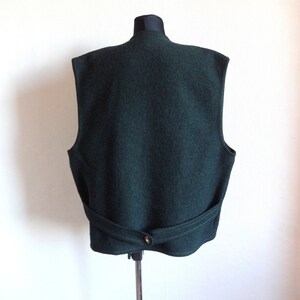 Puede incluir: Un chaleco de lana verde oscuro con cierre de bot&oacute;n y cintur&oacute;n en la espalda.