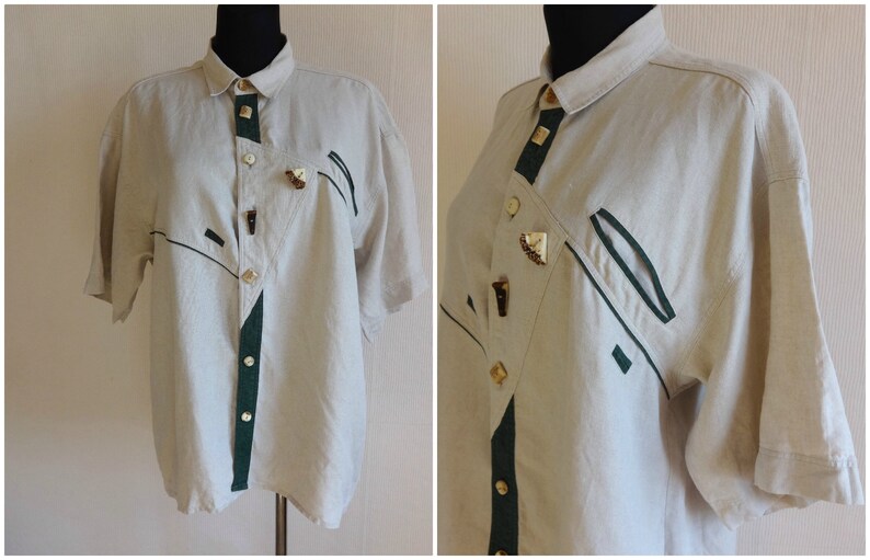 Pu&ograve; includere: Camicia beige a maniche corte con dettagli verde scuro e neri. La camicia presenta un'abbottonatura frontale con bottoni decorativi e disegni geometrici. Il colletto e il pannello frontale hanno finiture verde scuro.