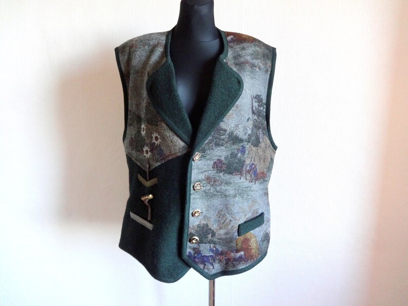 Puede incluir: Un chaleco estampado en verde y marr&oacute;n con cierre de botones y una pieza met&aacute;lica decorativa en el lado izquierdo.