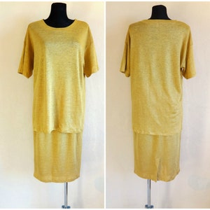 Könnte beinhalten: Ein senfgelbes Leinenkleid mit kurzen Ärmeln und einem Rock. Das Kleid hat eine einfache, lockere Passform.