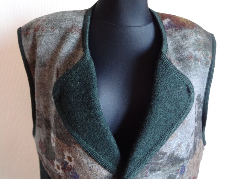 Puede incluir: Un chaleco sin mangas con cuello verde y un dise&ntilde;o estampado en tonos marrones, grises y blancos.