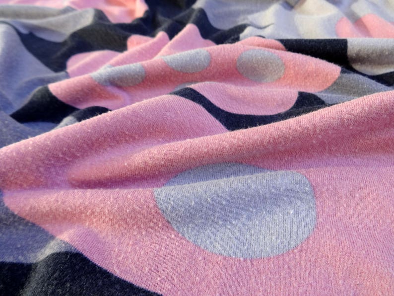 May include: Pink and gray fabric with a polka dot pattern. The fabric is soft and textured.