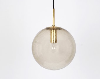 May include: A gold pendant light with a clear, textured glass globe shade.