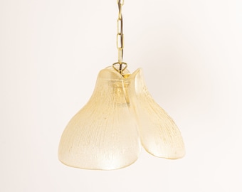 May include: A gold chain hangs from a ceiling fixture and supports a frosted glass pendant light with a unique flower-like shape.