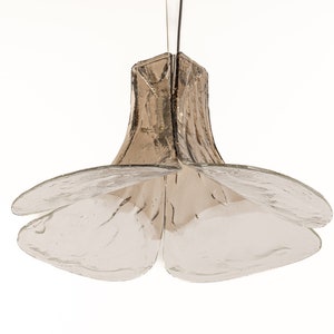 May include: A clear glass pendant light fixture with a flower-shaped design. The fixture has a brown, textured glass shade and four clear glass petals.