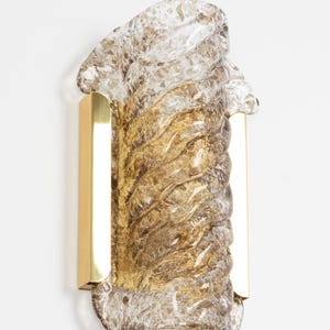 May include: A brown glass wall sconce with a textured, wavy design. The sconce is mounted on a brass bracket.