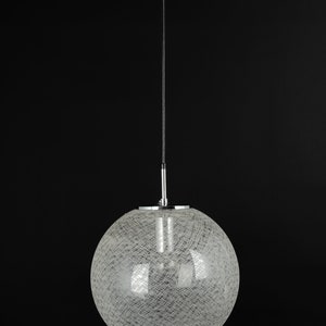 Peut inclure: Un luminaire suspendu rond en fil de fer blanc avec un cordon noir et une fixation au plafond noire.