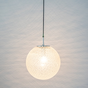 Peut inclure: Un luminaire rond blanc suspendu avec un abat-jour tiss&eacute;. La lumi&egrave;re est allum&eacute;e et diffuse une lueur chaude.