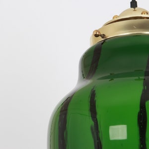 May include: A green glass pendant light with black stripes and a brass top.