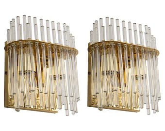 Peut inclure: Une paire d'appliques murales dorées avec des tubes en verre transparent. Les appliques ont un design moderne et seraient un excellent ajout à n'importe quelle maison.