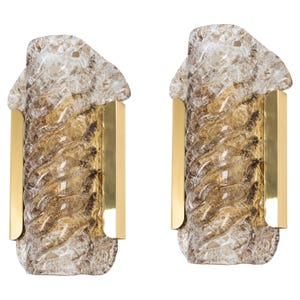 May include: A pair of gold wall sconces with clear and amber glass shades. The glass has a textured, swirling design.