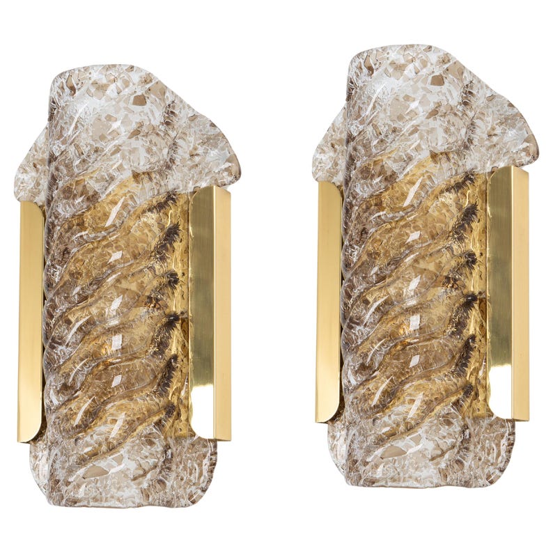 May include: A pair of gold wall sconces with clear and amber glass shades. The glass has a textured, swirling design.