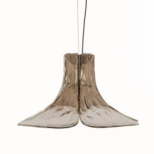 May include: A brown glass pendant light with a unique, organic shape. The light is suspended from a black wire.
