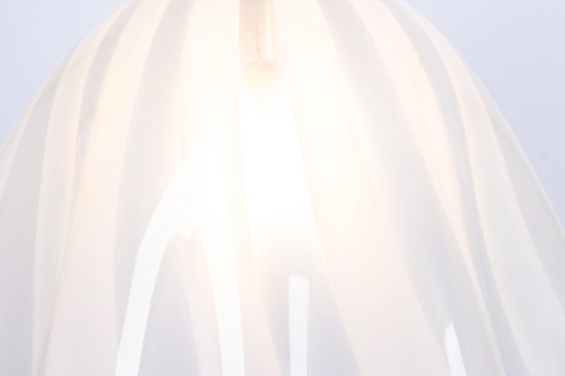 May include: White lampshade with a pleated design. The lampshade is made of a translucent material and has a soft, diffused light.