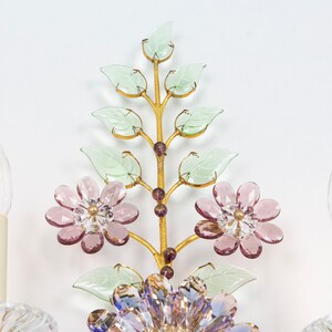 Puede incluir: Una l&aacute;mpara de pared de metal dorado con un dise&ntilde;o floral. La l&aacute;mpara tiene dos bombillas y est&aacute; decorada con flores y hojas de vidrio rosa y verde.