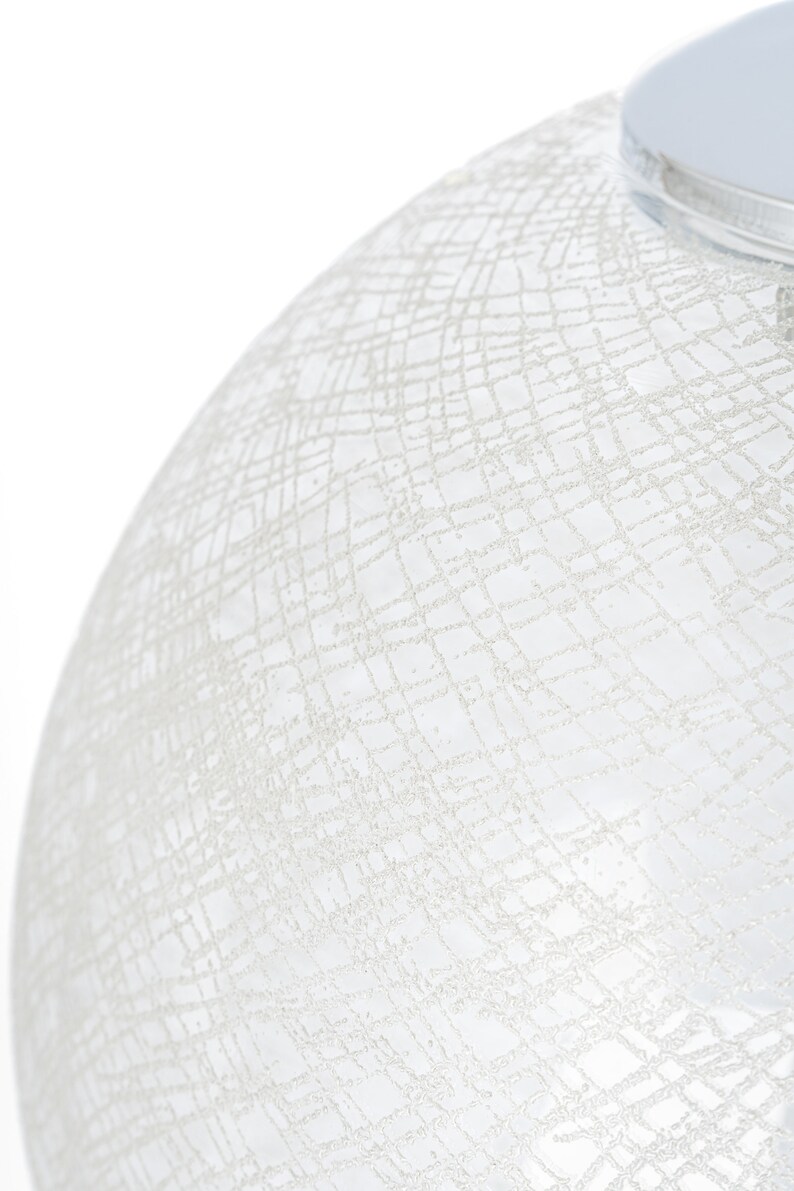 Peut inclure: Un abat-jour de lampe en verre blanc avec un motif d&eacute;licat et complexe de lignes entrecrois&eacute;es.