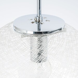 Peut inclure: Un luminaire de plafond chrom&eacute; avec un abat-jour blanc translucide en forme de filet.