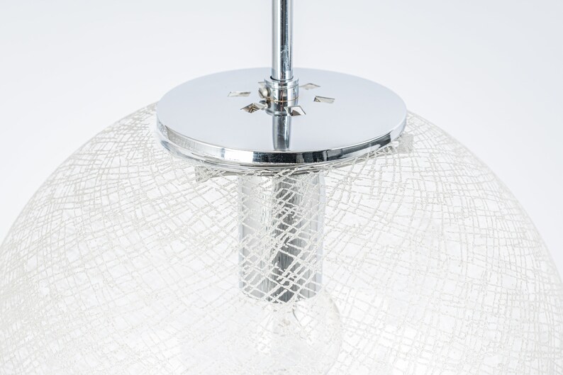 Peut inclure: Un luminaire de plafond chrom&eacute; avec un abat-jour blanc translucide en forme de filet.