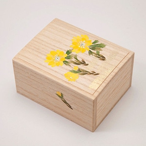 May include: A wooden box with a hinged lid, decorated with a floral design of yellow flowers and green leaves. The box is made of light wood and has a natural finish.