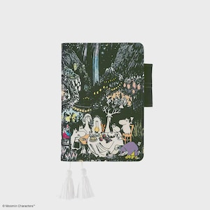 Può includere: Un diario verde scuro a tema Moomin con un'illustrazione di una scena di foresta stravagante. La copertina presenta un raduno di personaggi Moomin attorno a un tavolo, con un nappa e un cinturino verde scuro. Il diario è chiuso.
