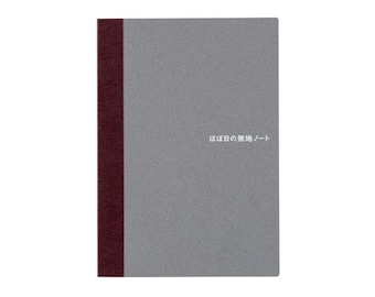 May include: A grey notebook with a burgundy spine. The cover features the Japanese text "ほぼ日の無地ノート" in white. The notebook is rectangular and has a minimalist design.