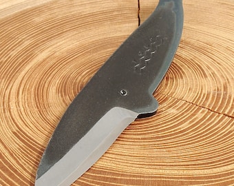 May include: A black whale-shaped knife with a silver blade. The knife has the words "Whale Knife" engraved on the handle.