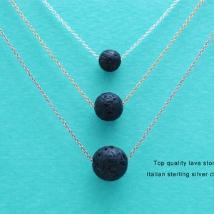 May include: Three silver chains with black lava stone beads. The chains are layered on top of each other, with the shortest chain at the top and the longest chain at the bottom. The beads are round and smooth. Top quality lava stone. Italian sterling silver chain.