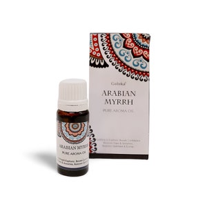 May include: A small brown glass bottle of Arabian Myrrh Pure Aroma Oil with a white cap, next to a matching box. The bottle and box feature decorative labels with text and a colorful mandala design. The text on the bottle reads "ARABIAN MYRRH PURE AROMA OIL".