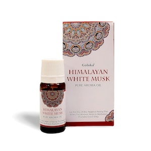 Puede incluir: Una botella de aceite aromático puro Himalayan White Musk con tapa blanca y etiqueta decorativa. El producto está junto a una caja con la misma marca y texto: "Puede deshacerse de cualquier sentimiento negativo que le cause ansiedad."