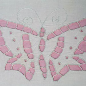 May include: Close-up of a white fabric with a repeating butterfly design. The butterflies are outlined in a light gray stitch and filled with pink segments. Small pink dots are scattered around the butterfly shapes.