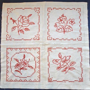Peut inclure: Quatre carrés de quilt blancs avec des motifs floraux rouges au point de croix. Chaque carré présente une fleur différente, dont une rose, et est encadré d'une bordure rouge au point de croix. Le texte "QUILT BLOCKS" est visible.