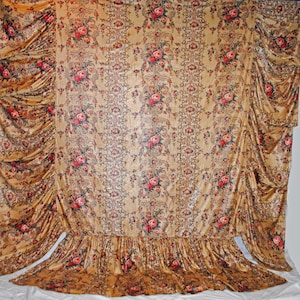 May include: A set of vintage-style curtains with a floral pattern. The curtains are a golden-brown color with a repeating design of red and pink roses and green leaves. The curtains have a ruffled edge at the bottom and are draped on the sides.