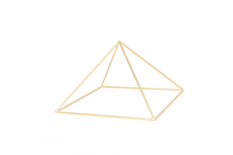 May include: A gold metal pyramid shaped frame. The frame is made of thin wire and is open on all sides.