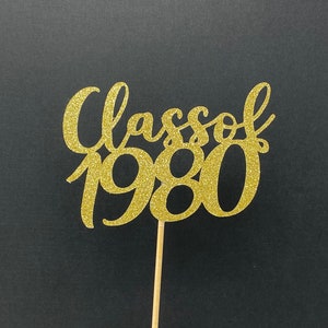 May include: Gold glitter cake topper with the text "Class of 1980".