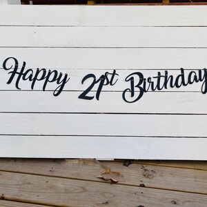 K&ouml;nnte beinhalten: Schwarz-wei&szlig;es Banner mit dem Text "Happy 21st Birthday" auf wei&szlig;em Holzgrund.