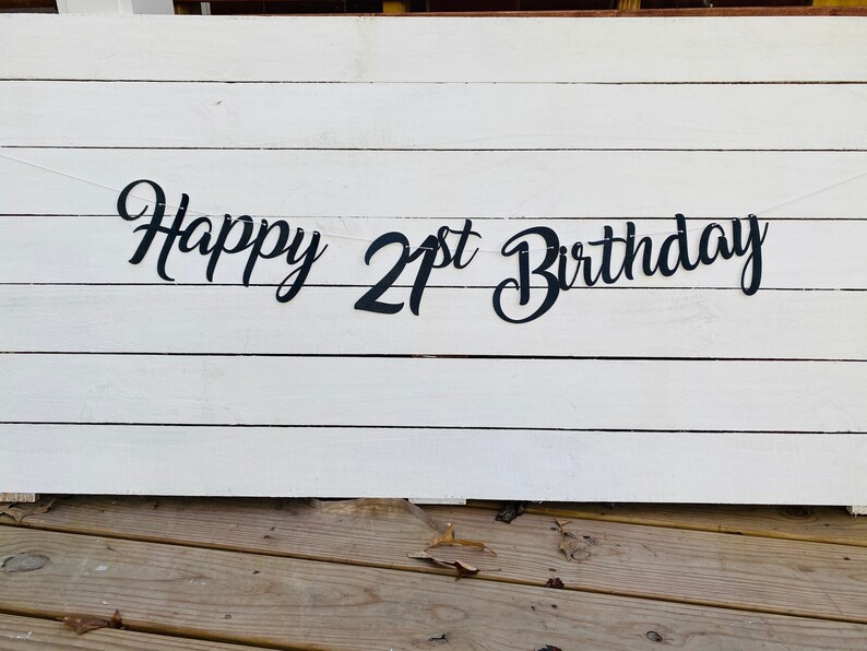 K&ouml;nnte beinhalten: Schwarz-wei&szlig;es Banner mit dem Text "Happy 21st Birthday" auf wei&szlig;em Holzgrund.