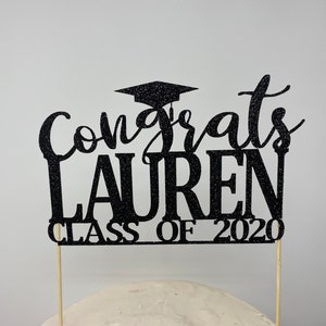 May include: Black glitter graduation cake topper with the text "Congrats Lauren Class of 2020".