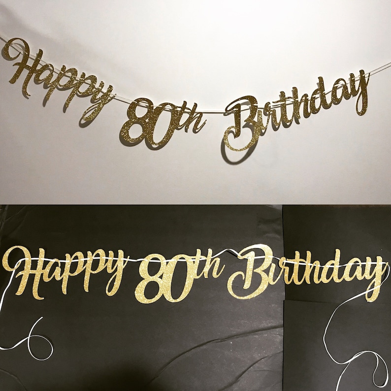 K&ouml;nnte beinhalten: Goldene Glitzergirlande mit dem Text "Happy 80th Birthday".