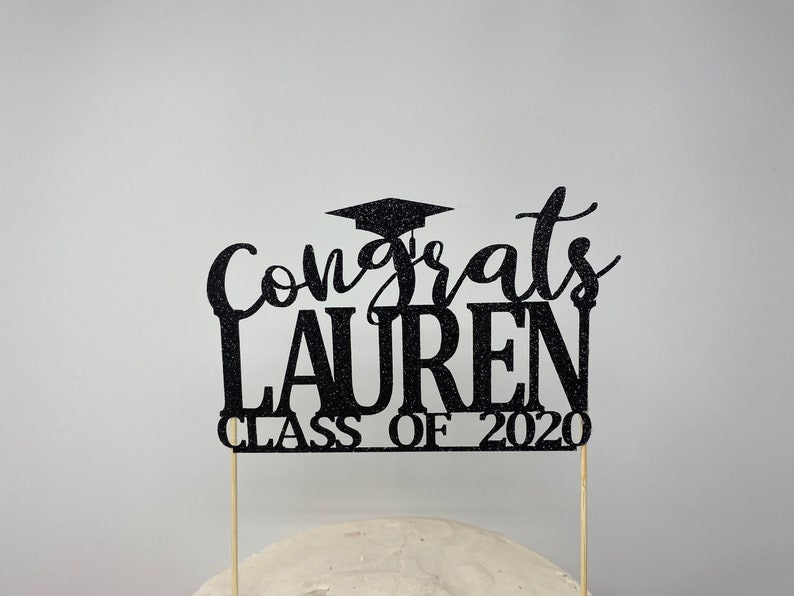 May include: Black glitter graduation cake topper with the text "Congrats Lauren Class of 2020".