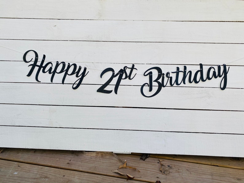 K&ouml;nnte beinhalten: Schwarz-wei&szlig;es Banner mit dem Text "Happy 21st Birthday" auf wei&szlig;em Holzgrund.