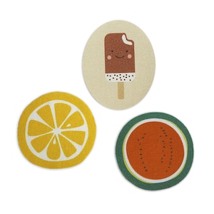 Op de afbeelding: Drie ronde stoffen onderzetters met een zomerthema. Een onderzetter heeft een citroen, een andere een watermeloen en de derde een glimlachende chocolade-ijsje.